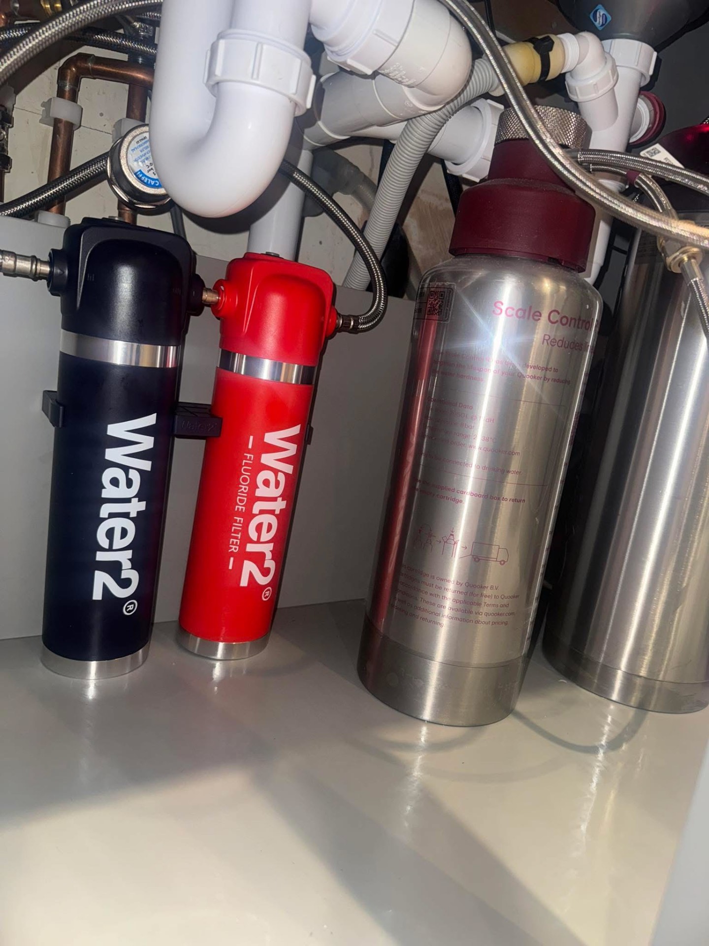 Under-sink water filtration and scale control system with red and black filter canisters
